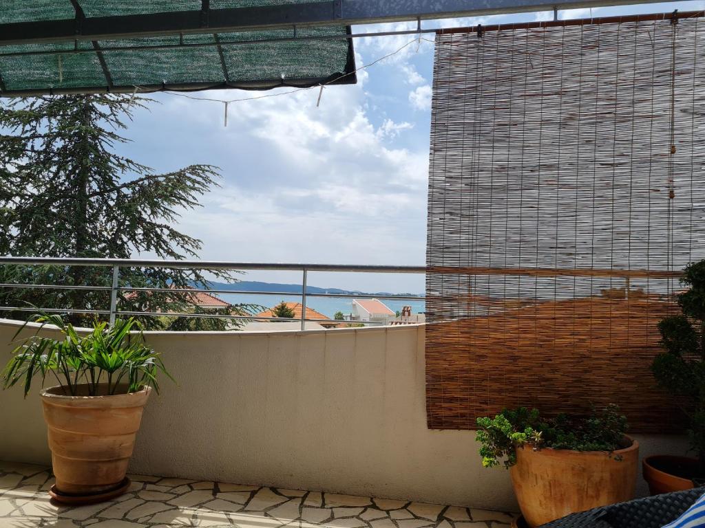 a balcony with plants and a view of the ocean at Apartments Lucija-Klara in Brodarica