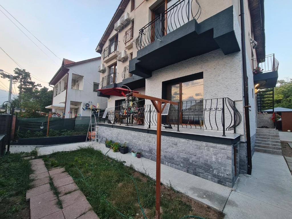 a building with a balcony and a pole in front of it at Vila SIA Eforie Sud in Eforie Sud