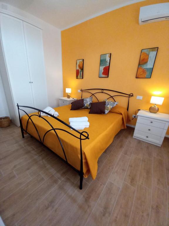 a bedroom with a bed with a yellow wall at Divina Cuspide in Guspini