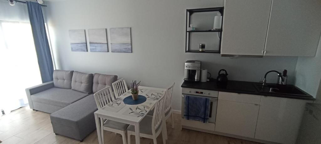 a kitchen with a couch and a table and chairs at Błękitne zacisze in Gdańsk