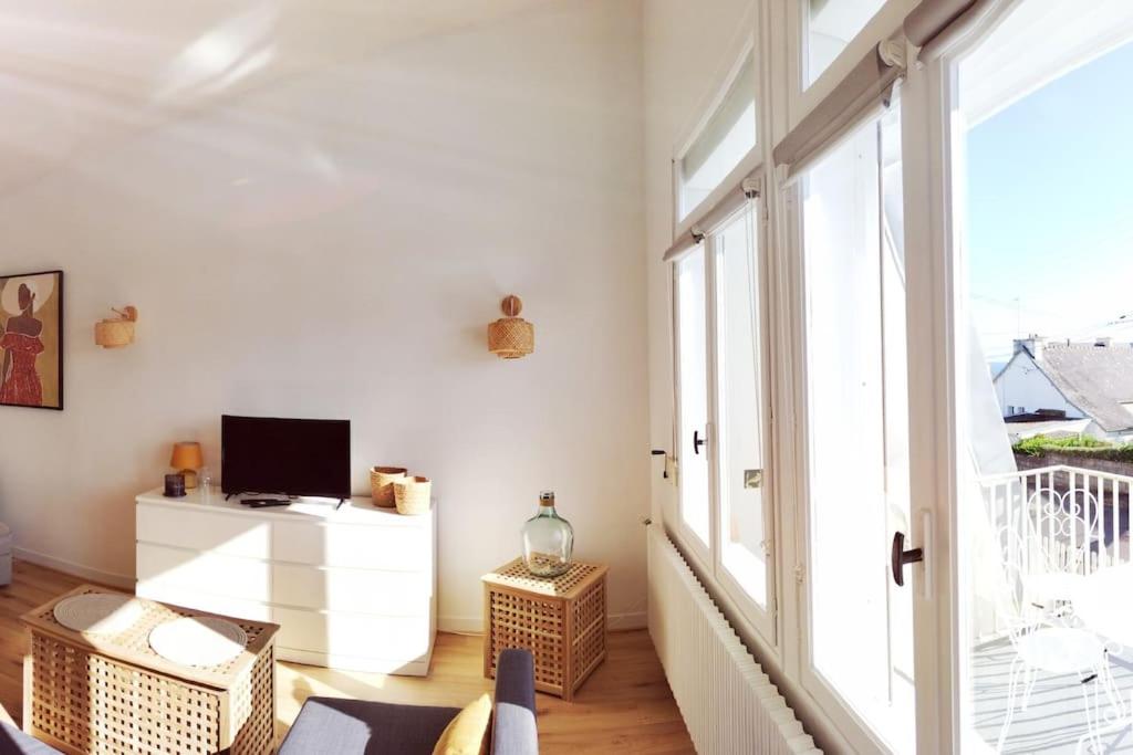 uma sala de estar com televisão e uma grande janela em Appartement à 50 m de la plage em Audierne