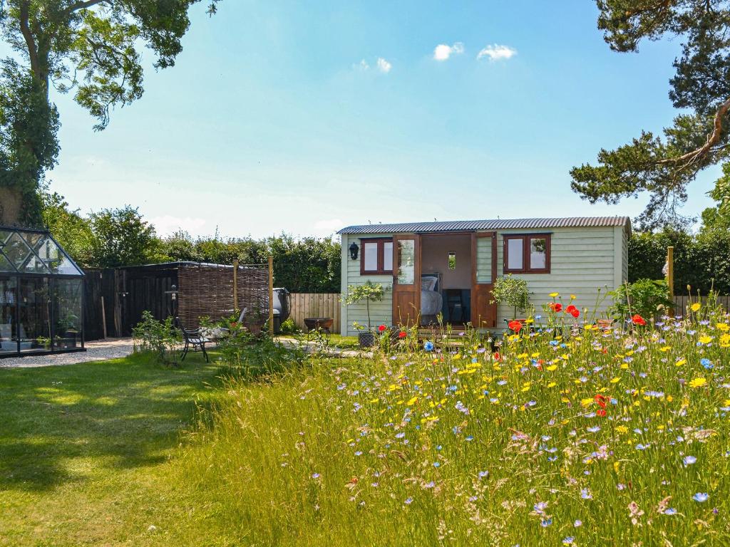 a garden with a tiny house and flowers at Wildflower View in Lowthorpe