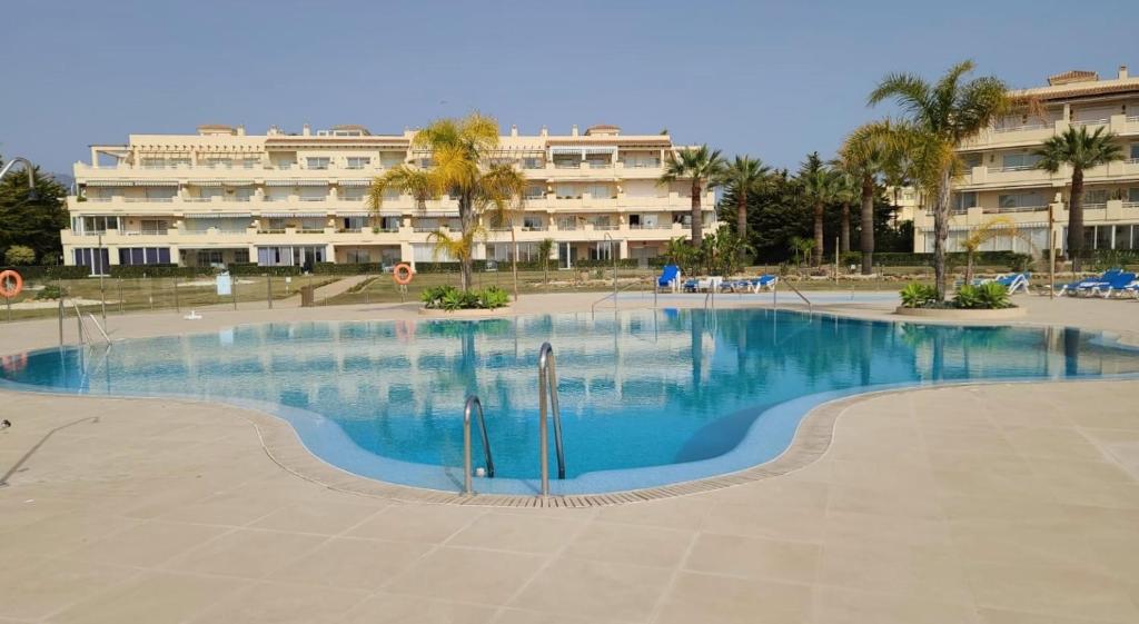 a large swimming pool in front of a building at 2 bedroom apartment overlooking Mediterranean, 2 outdoor pools in Mijas Costa
