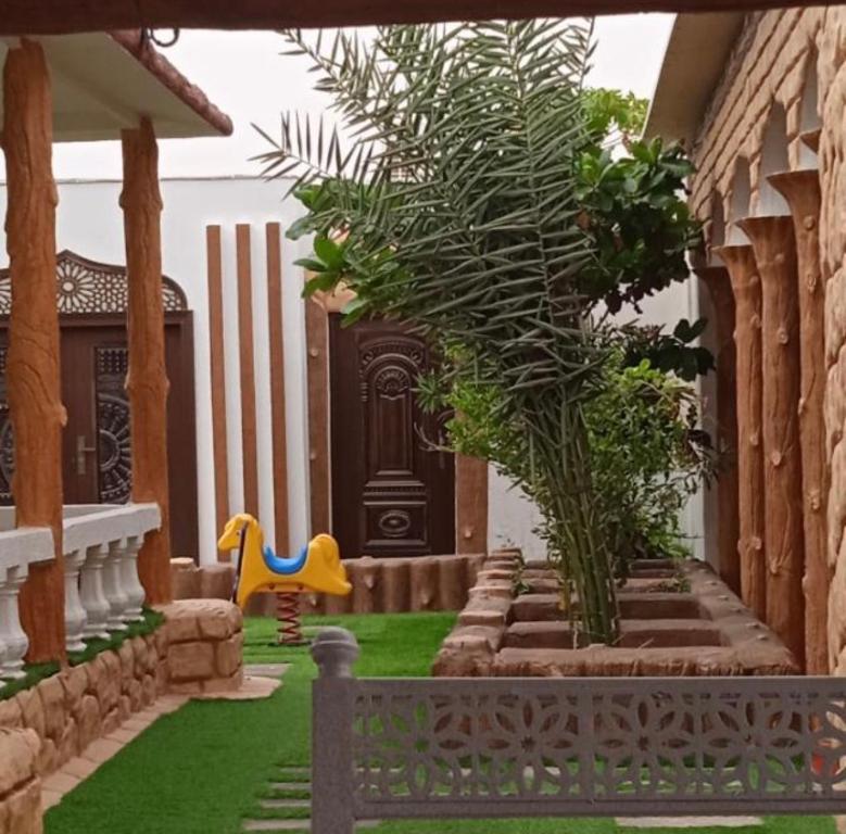 een tuin met een bankje voor een huis bij أستراحة السعادة in Jalan Bani Buhassan