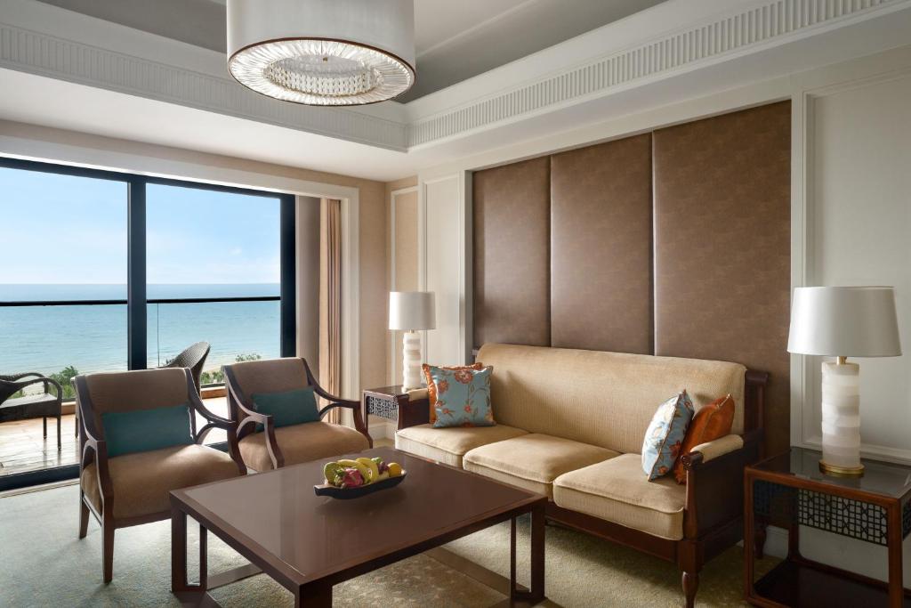 a living room with a couch and a table at Grand Hotel Haikou - Managed by Accor in Haikou