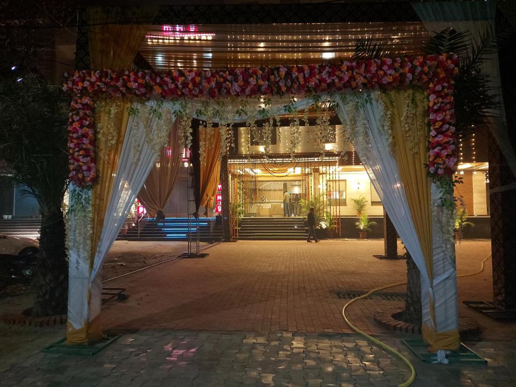 an entrance to a venue with a floral arch at night at Hotel Endora in Patiāla