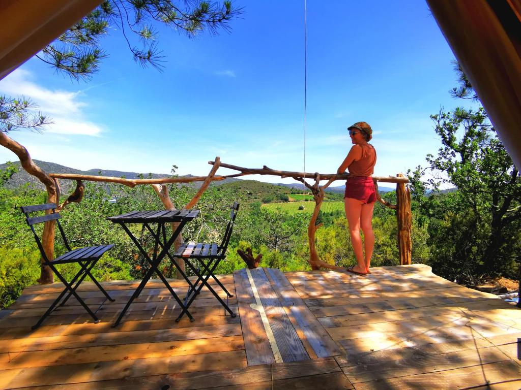 une femme debout au-dessus d'un pont avec vue dans l'établissement Grande Tente Tipi avec magnifique vue, à Rigarda