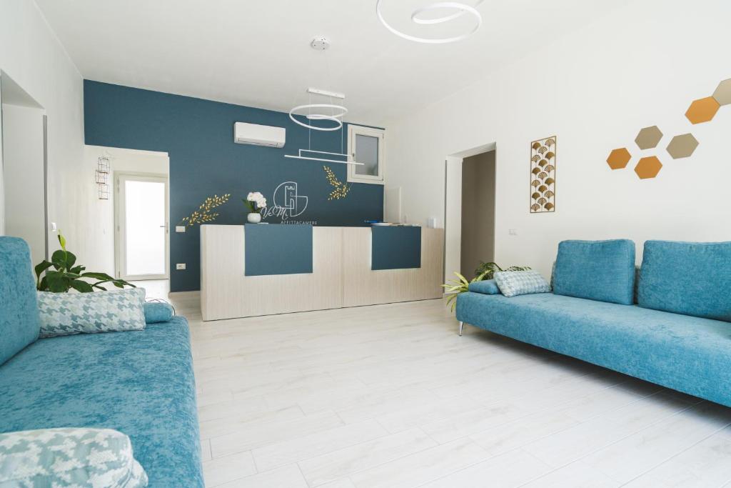 sala de estar con 2 sofás azules y cocina en VeMi Affittacamere, en Posada