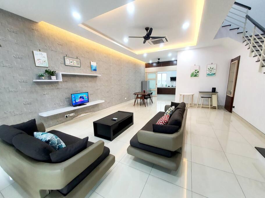 a living room with two couches and a tv at MODERN STYLISH 2STOREY HOUSE 8PAX@ALMA NEAR JUSCO in Bukit Mertajam