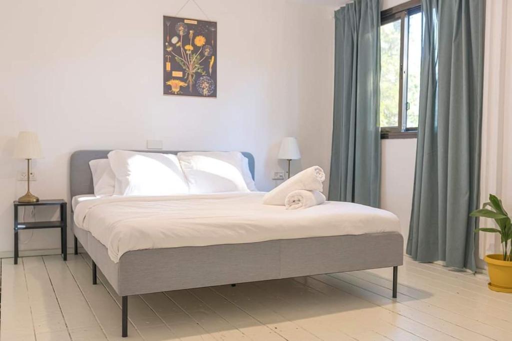 Schlafzimmer mit einem Bett und einem Fenster in der Unterkunft מקום לנשום בית אירוח in Sheʼar Yashuv
