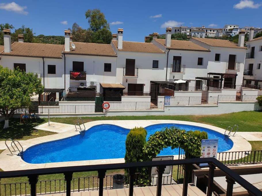 埃爾博斯克的住宿－CASA RURAL EN URB LAs TRUCHAS-EL BOSQUE，享有游泳池的景色,游泳池的建筑背景