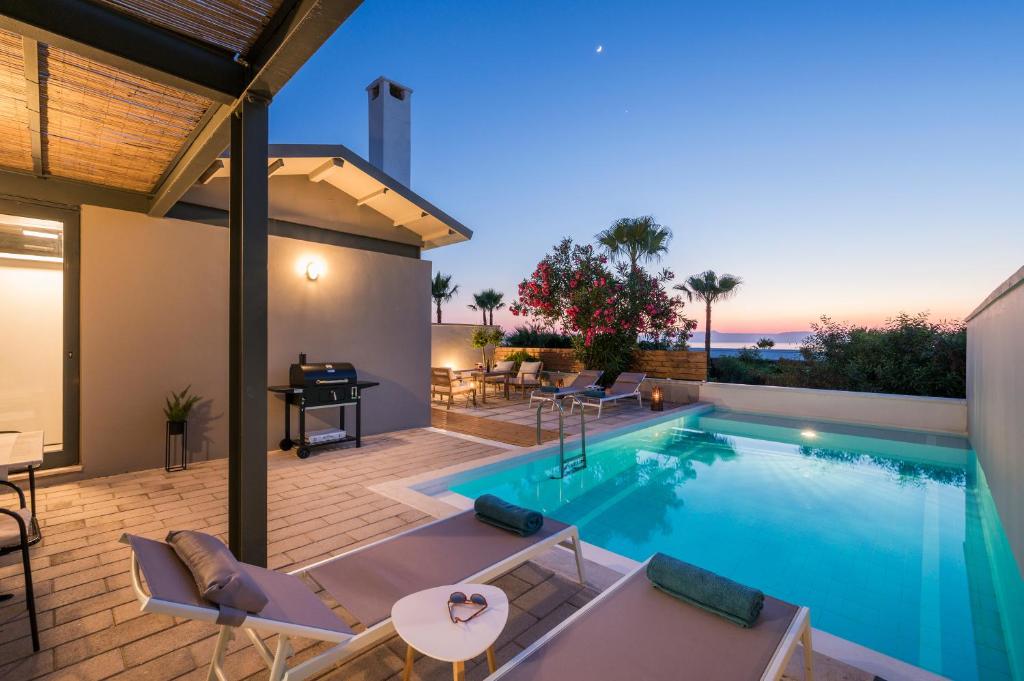 Natura Hill Villa III Sunset View في كونوبيدهيانا: مسبح مع كراسي وطاولة على فناء