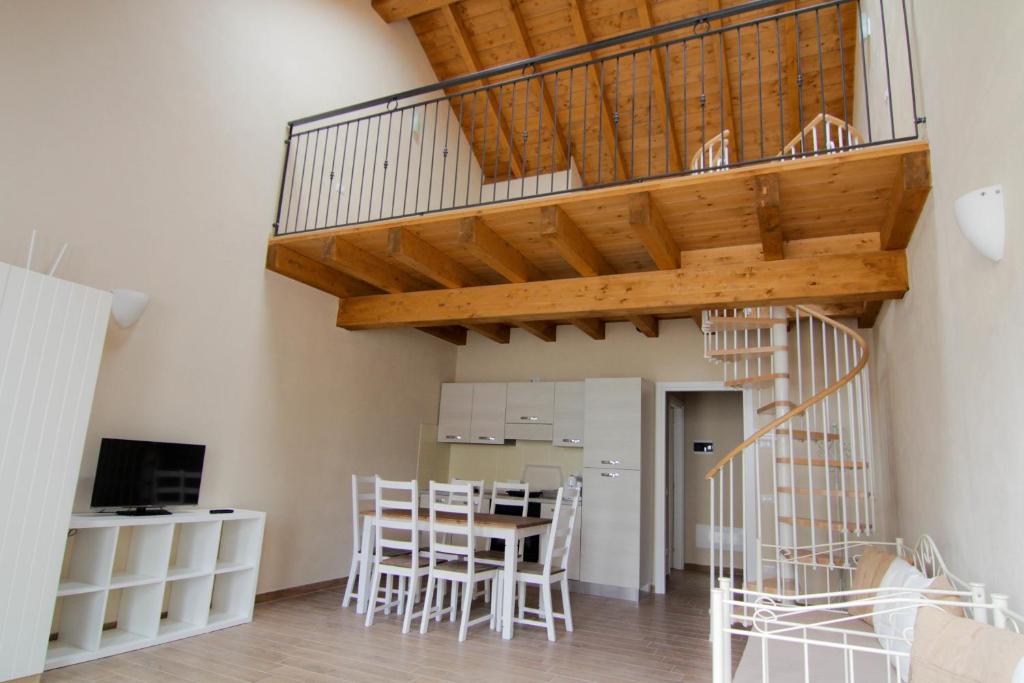 een trap in een woonkamer met een tafel en stoelen bij Agriturismo Cascina della Fontana in Lodi