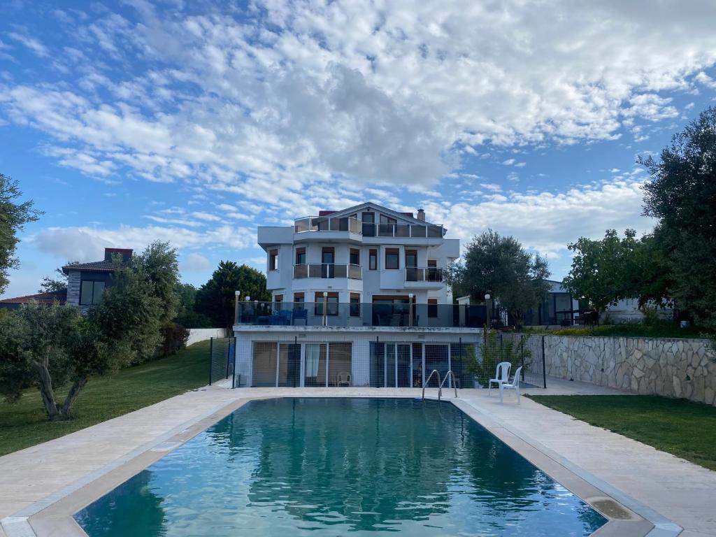 a large house with a swimming pool in front of it at Nefes URLA Villa Sea View. in Urla
