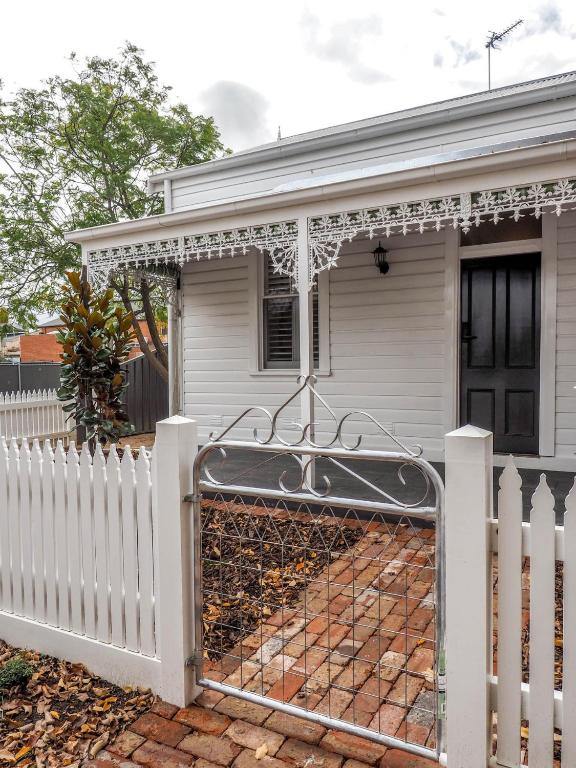 a white fence with a gate in front of a house at Central Bendigo Cottage Charm in Bendigo