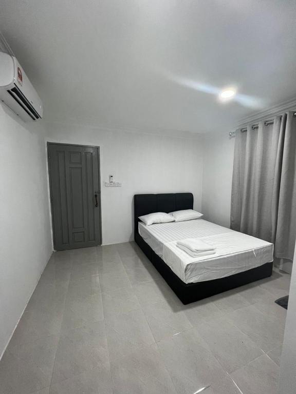 a white room with a bed and a door at Demo Inn in Bachok