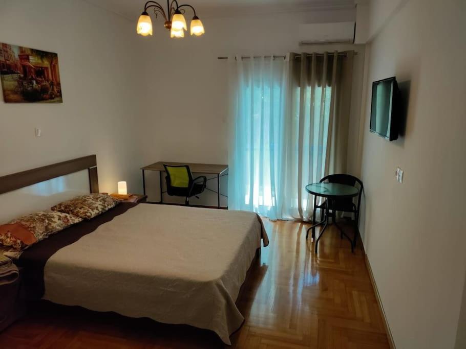 a bedroom with a bed and a table and a television at VeryBeautifulSpaciousAppartment in Athens