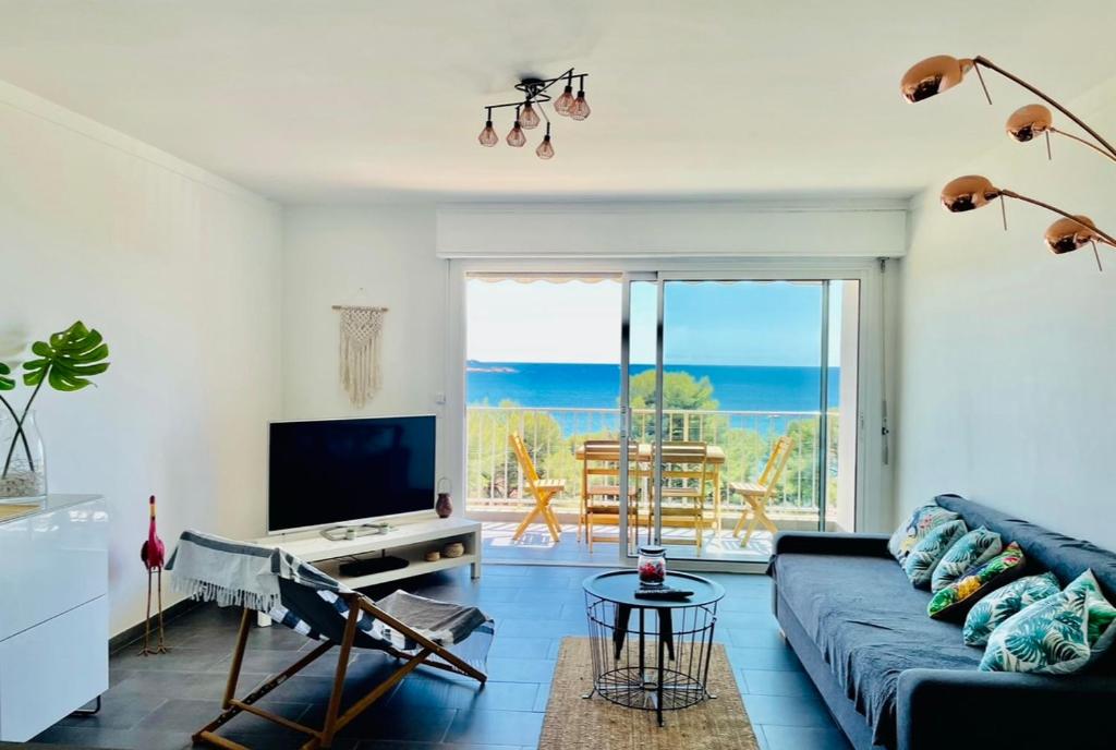 a living room with a blue couch and a television at Mango Beach Bandol in Bandol