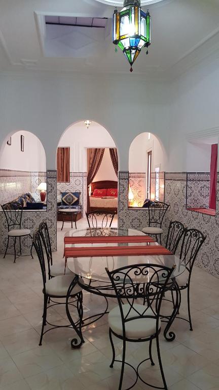 a room with chairs and a table and a bedroom at Alan's house Asilah in Asilah