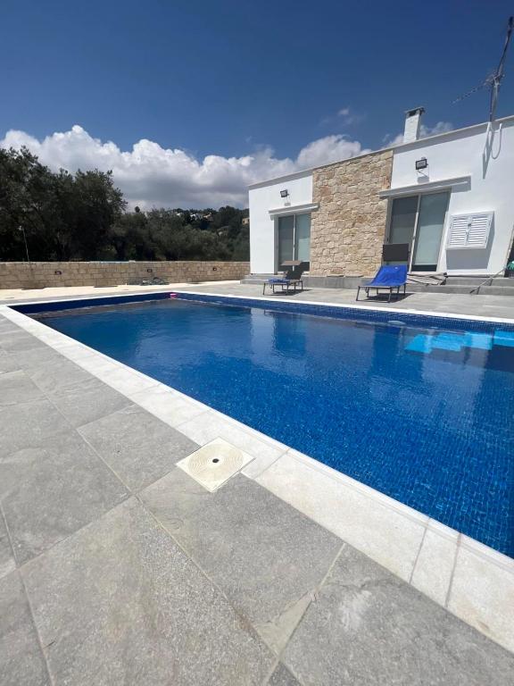 a swimming pool in front of a house at Walnut Cozy House in Goudhi
