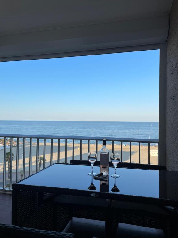 - une table avec des verres à vin sur un balcon donnant sur la plage dans l'établissement « Le Bellevue » by P&T, à Canet