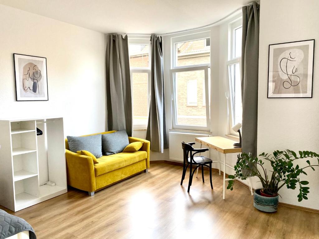 uma sala de estar com um sofá amarelo e uma mesa em 2 Rooms, free Parking, 25 min to Düsseldorf, 150 Mbps WLAN em Duisburgo
