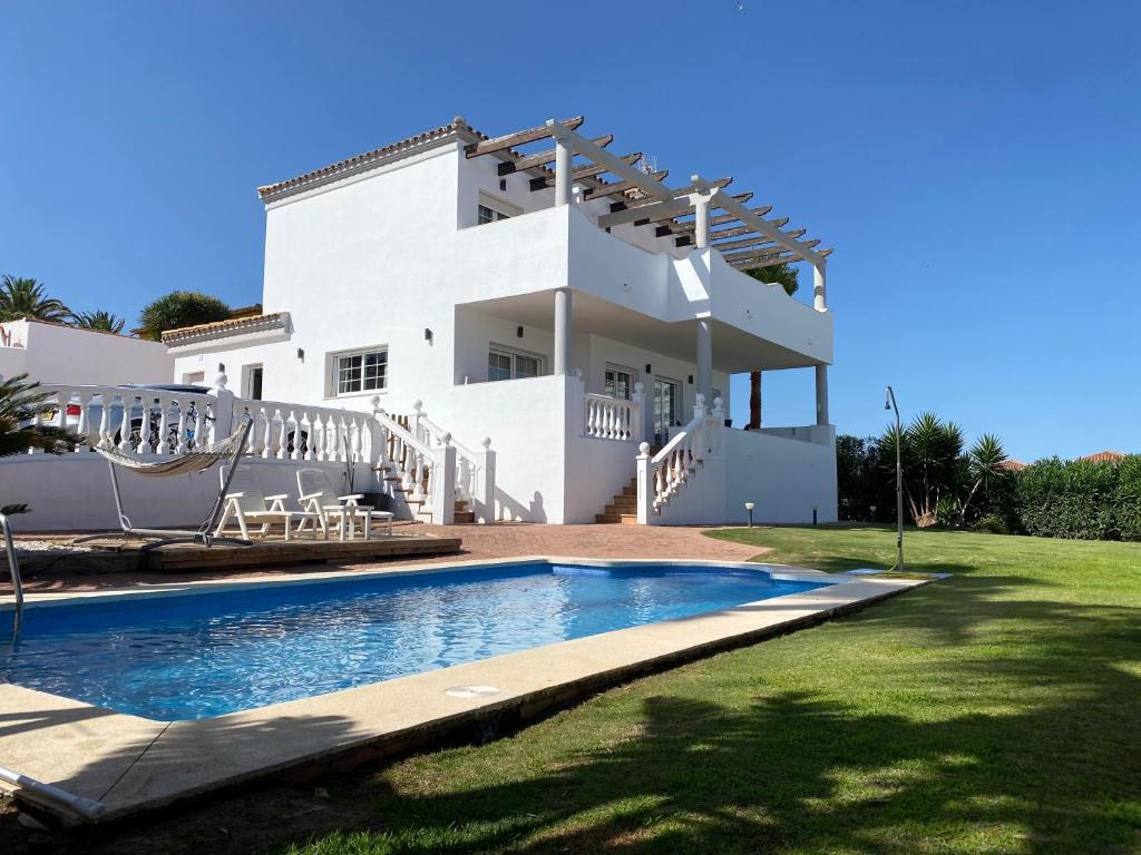 una casa blanca con piscina frente a ella en Villa Las Americas en Sotogrande
