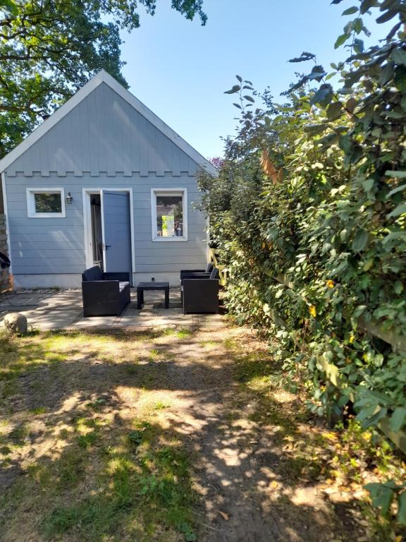una casa blanca con un banco delante de un patio en Onder de Eiken, en Noord-Sleen