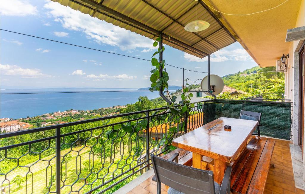 d'un balcon avec une table en bois et une vue sur l'océan. dans l'établissement Nice Apartment In Lovran With Kitchen, à Lovran