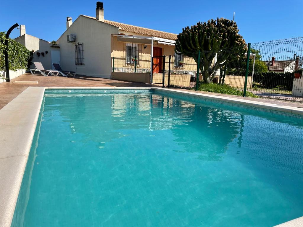 uma piscina com água azul em frente a uma casa em Finca Liarte em Fuente-Álamo de Murcia