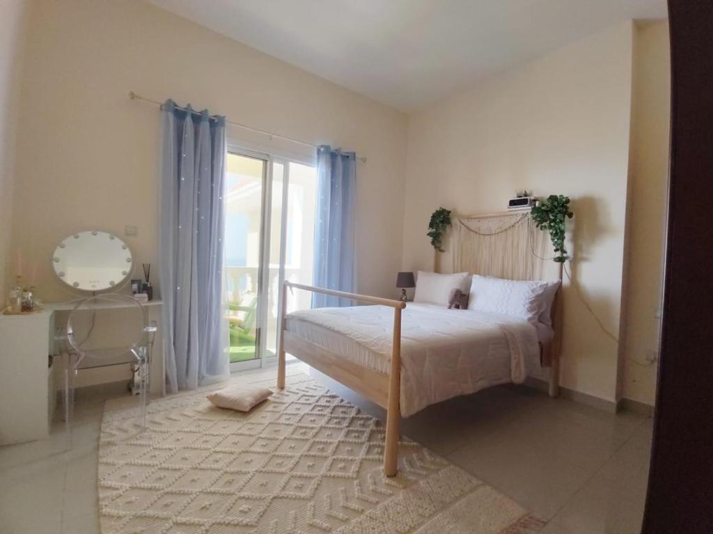 a bedroom with a bed and a desk and a window at House 369 in Ras al Khaimah