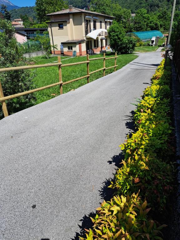 a road with flowers on the side of a fence at Green & Blue House in Valbrona