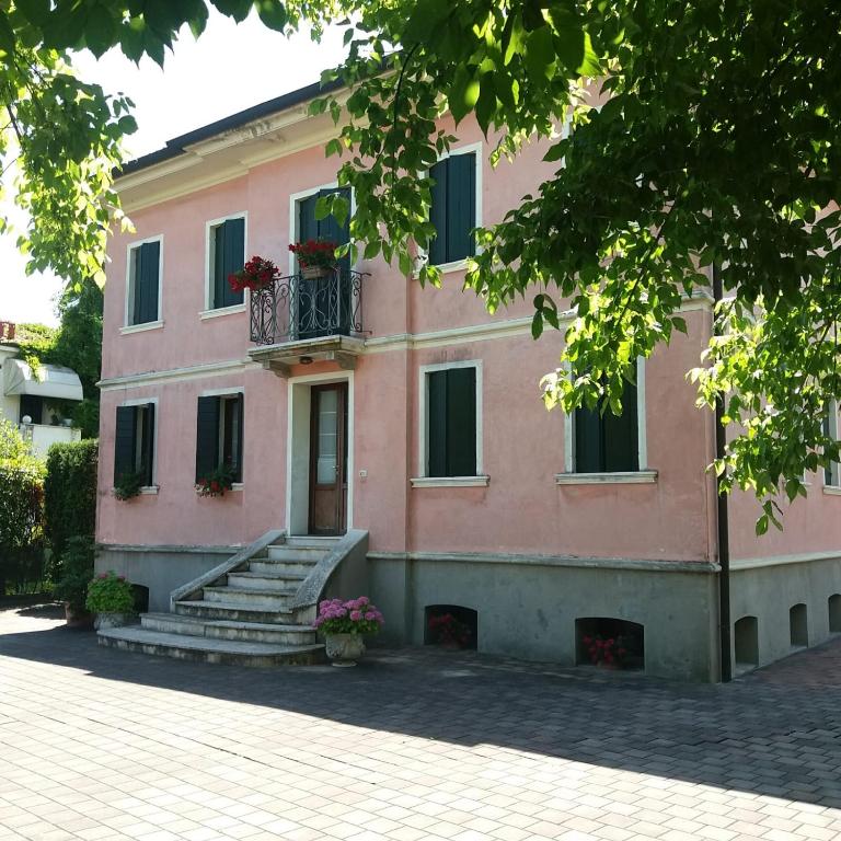 a pink building with stairs and a balcony at Villa Trevisi - ROOMS -free parking in Treviso