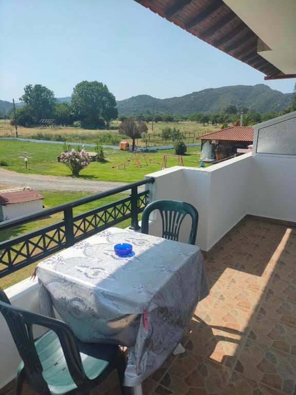 a table and chairs on a balcony with a view of a field at Vigla House in Sykia Chalkidikis