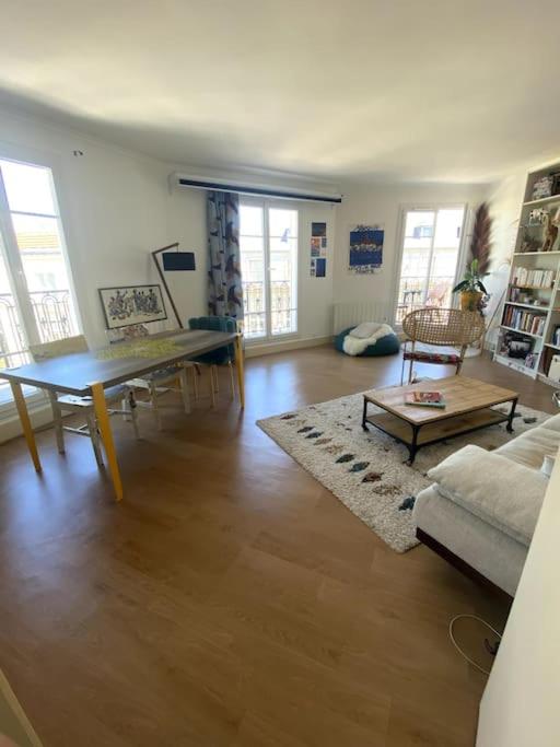 un salon avec une table et un canapé dans l'établissement Paris : superbe appartement au coeur du Marais, à Paris