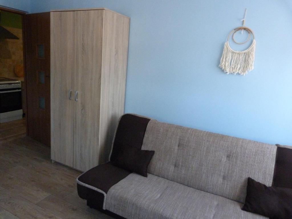 ein Wohnzimmer mit einem Sofa und einer Uhr an der Wand in der Unterkunft Pokoje gościnne u Steni in Kudowa-Zdrój