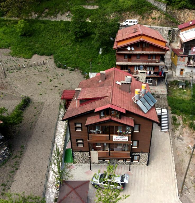 a large building with a red roof and a house at Karagöz Süit in Uzungöl