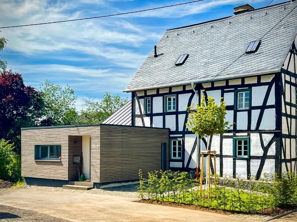 een zwart-wit huis met een garage bij Landleben auf Zeit in Utzerath