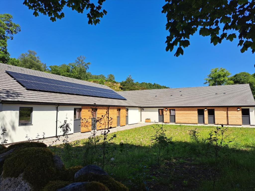 a building with solar panels on the side of it at An Spiris Accommodation at Dundreggan Rewilding Centre in Dundreggan