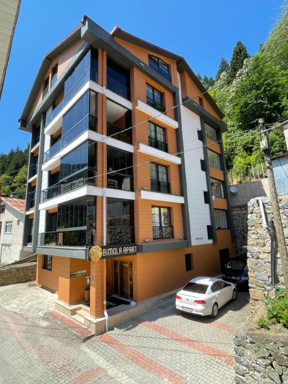 a building with a car parked in front of it at Bimola Rezidans in Uzungöl