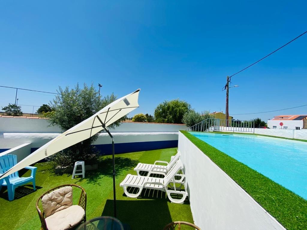 a view of a swimming pool with chairs and a swing at A Janela do Alentejo in Campinho