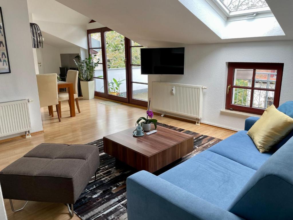 a living room with a blue couch and a coffee table at Charmante Dachgeschoss Wohnung in Leipzig