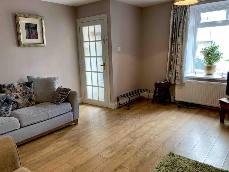 a living room with a couch and a hard wood floor at Spacious cottage, central Ballycastle. in Ballycastle