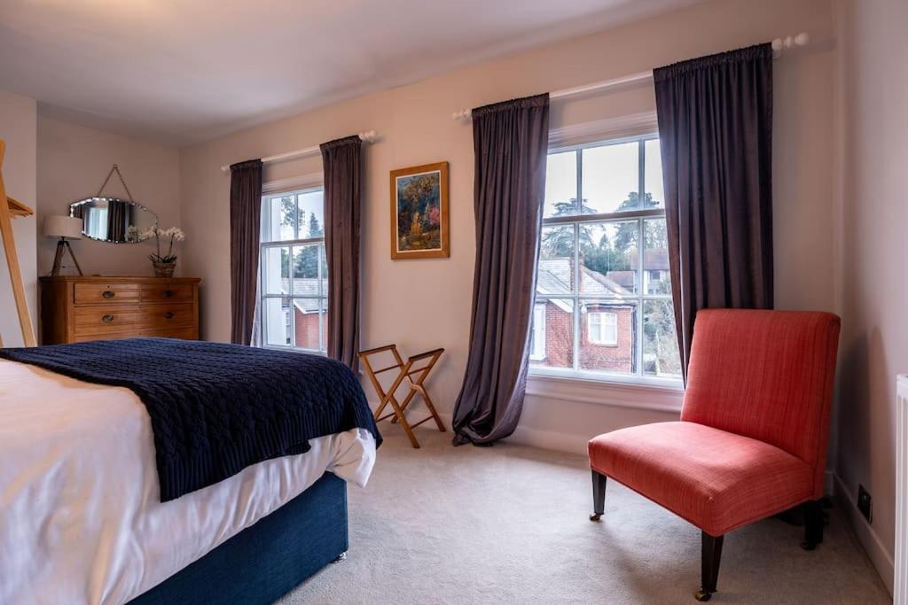 a bedroom with a bed and a chair and windows at Beautiful & Spacious Retreat in Winchester in Winchester