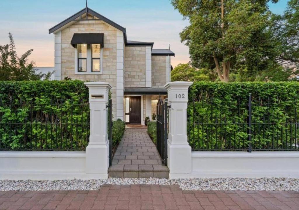 a house with a gate and a brick driveway at Executive living in City fringe location in Glenunga