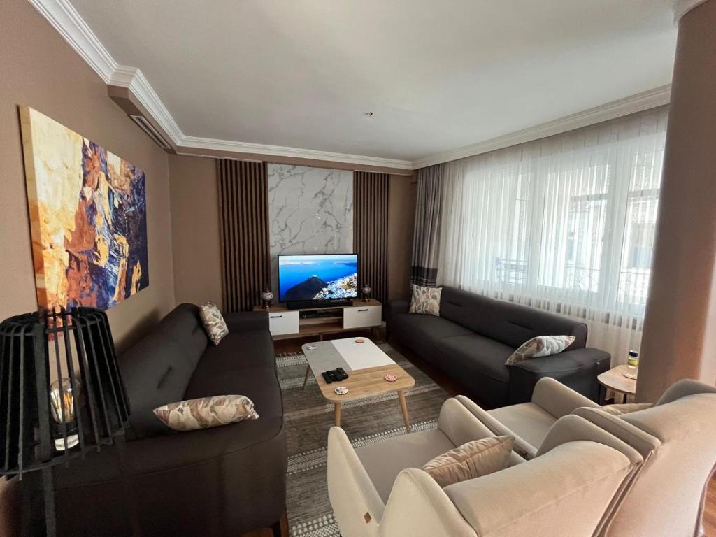 een woonkamer met een bank en een televisie bij Sisli Osmanbey Taksim large terrace, quietness and space in Istanbul