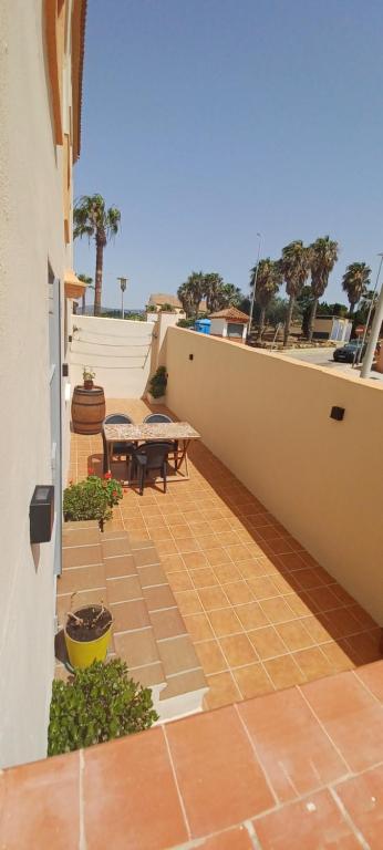 un patio con mesa y bancos en un edificio en Encanto de Tarifa, en Tarifa