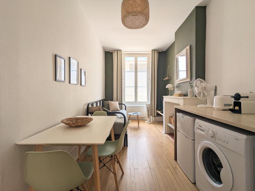 Le DODO Part-Dieu في ليون: مطبخ وغرفة معيشة مع طاولة وغسالة ملابس