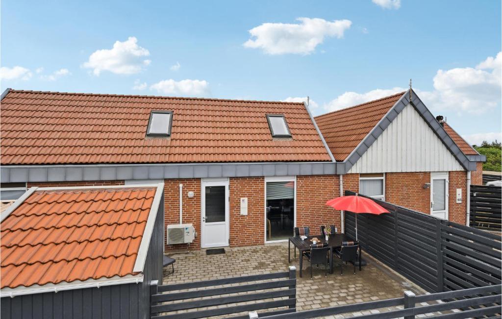 BjerregårdにあるAmazing Home In Hvide Sande With Wifiの赤い屋根の家、バルコニー(テーブル付)