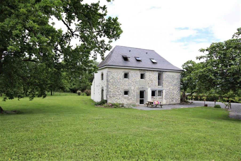 a stone house in a field of green grass at Bonnevigne in Lys